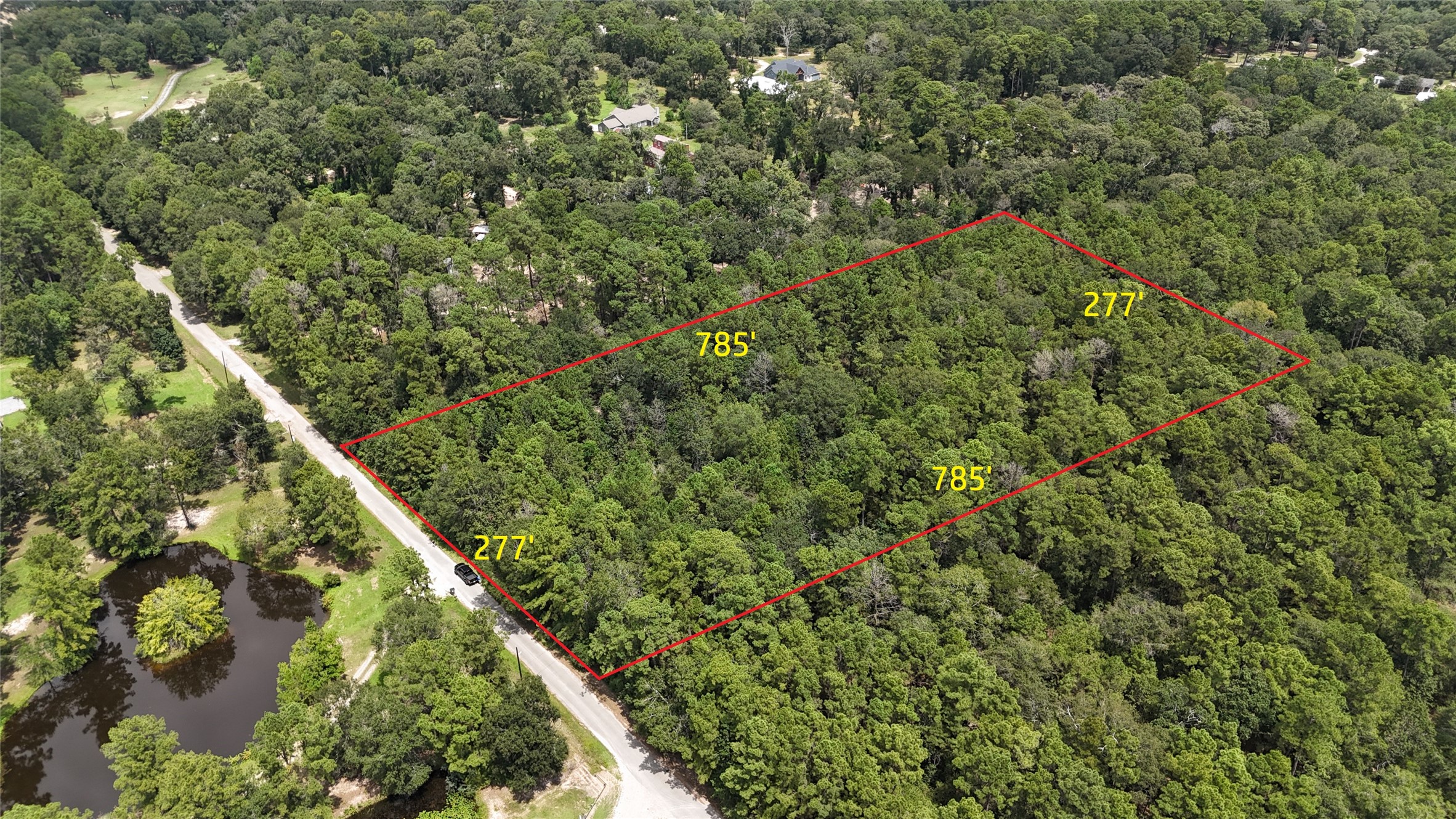 15455 Sharon Lane Conroe, TX 77302 - Photo 5 of 9 a view of a house with a lush green forest