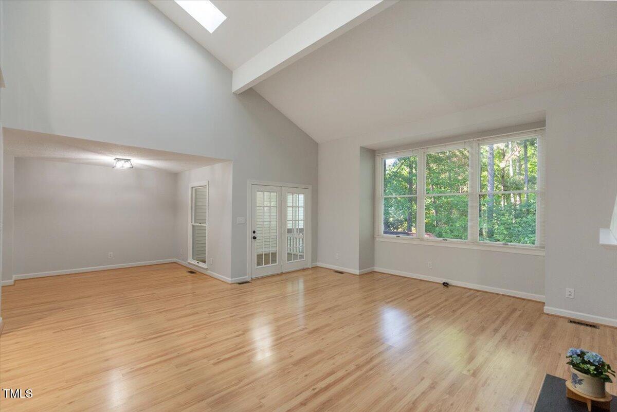 411 Brampton Close Pittsboro, NC 27312 - Photo 12 of 71 a view of an empty room with wooden floor and a window