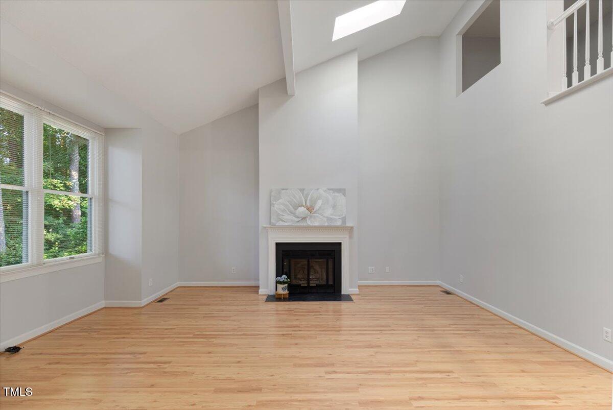 411 Brampton Close Pittsboro, NC 27312 - Photo 13 of 71 a view of an empty room with wooden floor and a window