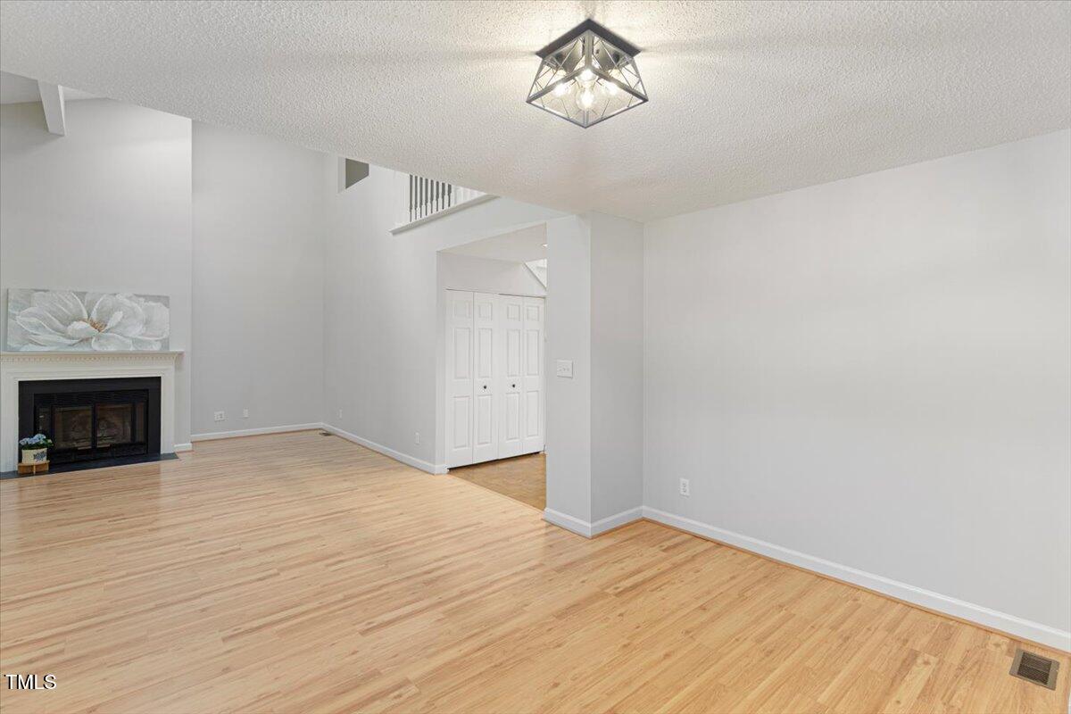 411 Brampton Close Pittsboro, NC 27312 - Photo 7 of 71 a view of empty room with wooden floor and fireplace