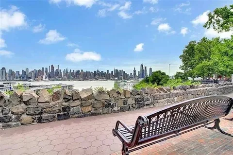 a view of a terrace with lawn chairs and iron fence