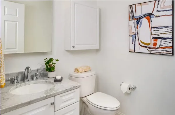 a bathroom with a granite countertop sink mirror vanity and toilet