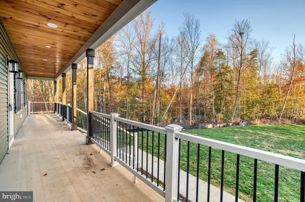 a large tree in front of a house with a garden