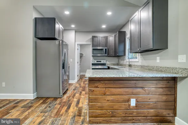 a kitchen with stainless steel appliances granite countertop wooden cabinets and a granite counter tops