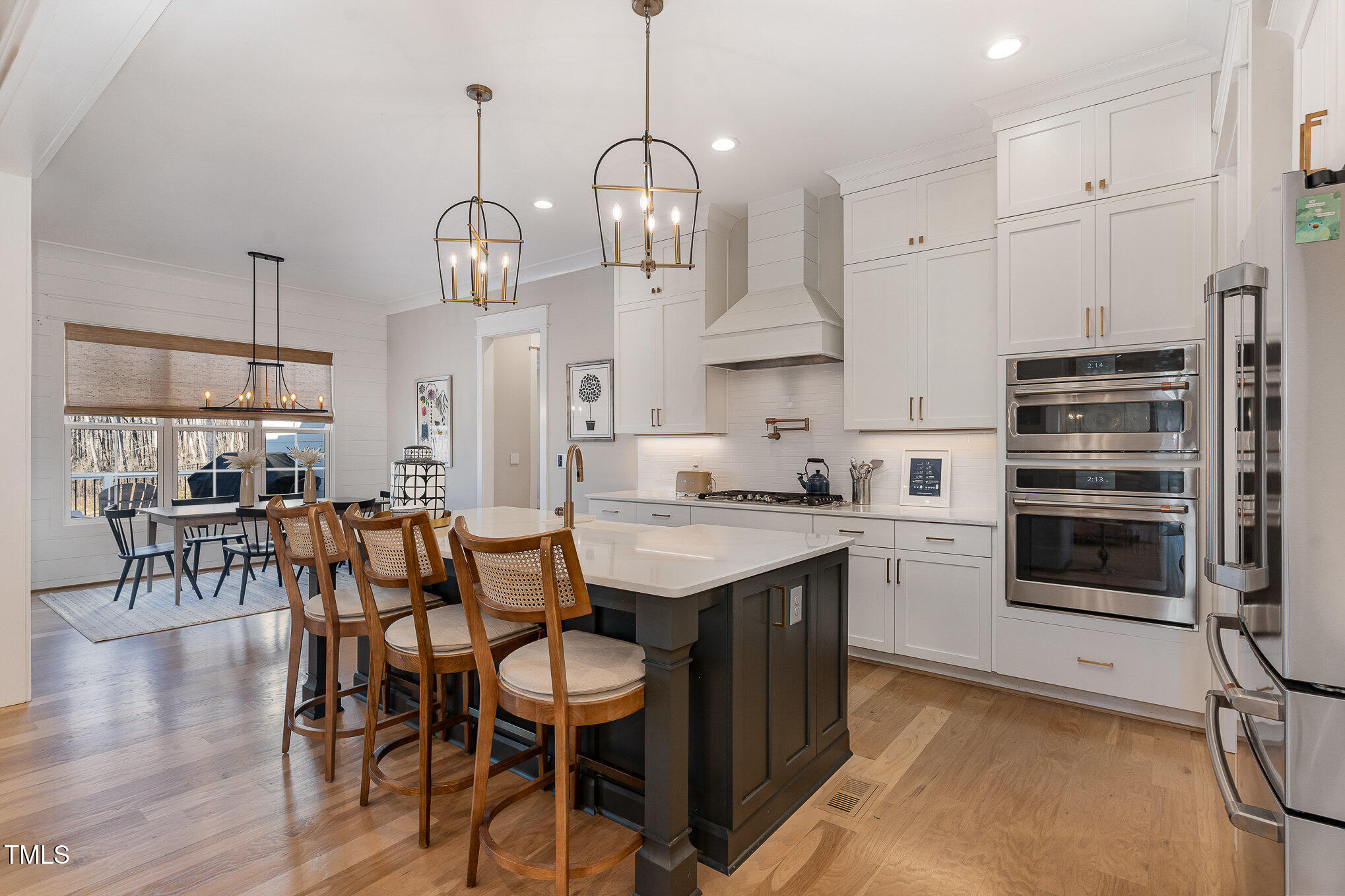 403 Stonecrest Way Pittsboro, NC 27312 - Photo 11 of 65 a kitchen with stainless steel appliances kitchen island granite countertop a table chairs in it and wooden floors