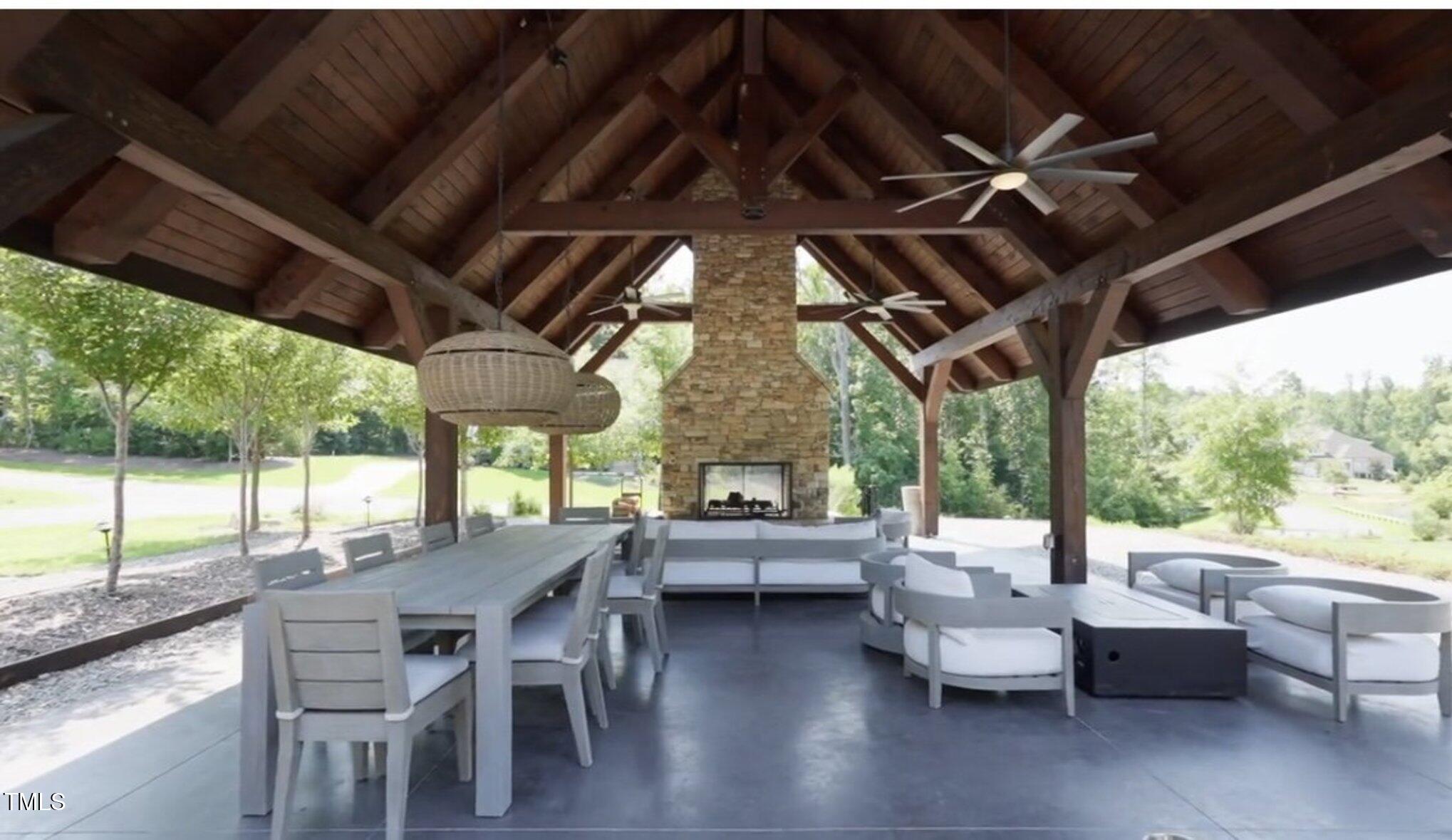 403 Stonecrest Way Pittsboro, NC 27312 - Photo 63 of 65 a view of a patio with table and chairs and floor to ceiling window with wooden floor