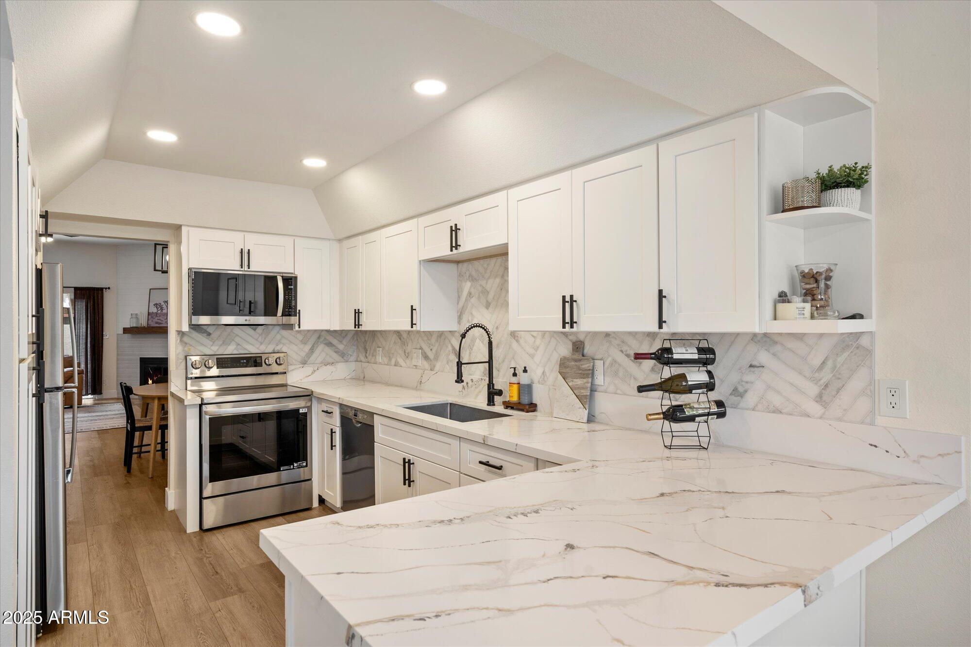3415 North 36th Street, Unit 4 Phoenix, AZ 85018 - Photo 6 of 15 a kitchen with stainless steel appliances kitchen island granite countertop a stove and a sink
