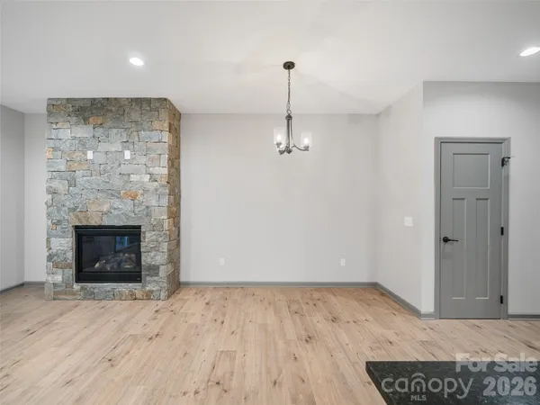 a view of empty room with wooden floor and fireplace
