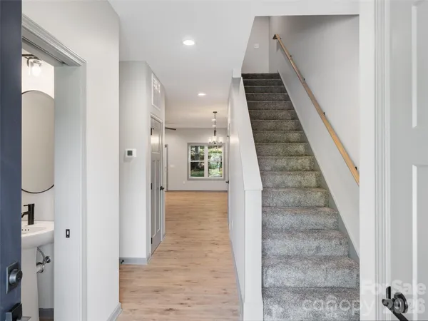 a view of a hallway with wooden floor and staircase