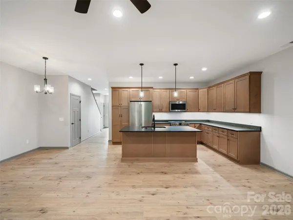 a large kitchen with kitchen island a sink stainless steel appliances and cabinets