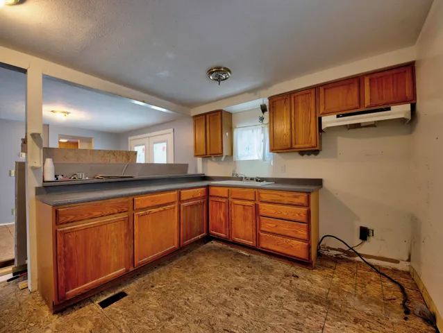 a kitchen with stainless steel appliances granite countertop a stove a sink and a microwave