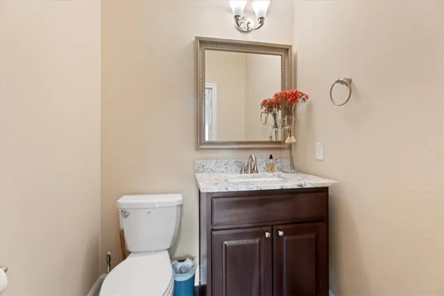 a bathroom with a toilet a sink and mirror