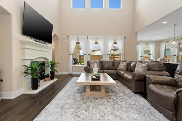 a living room with furniture a flat screen tv and a large window