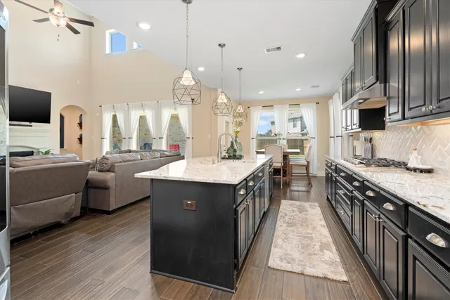 a kitchen with stainless steel appliances granite countertop a sink a stove and a refrigerator