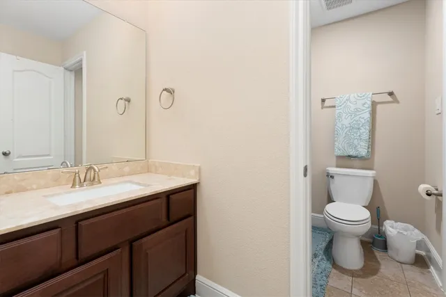 a bathroom with a granite countertop sink a toilet and a mirror