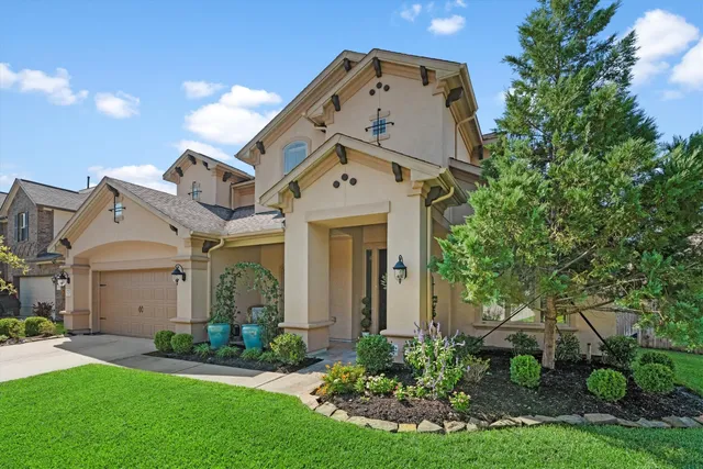 front view of a house with a small yard and a large tree
