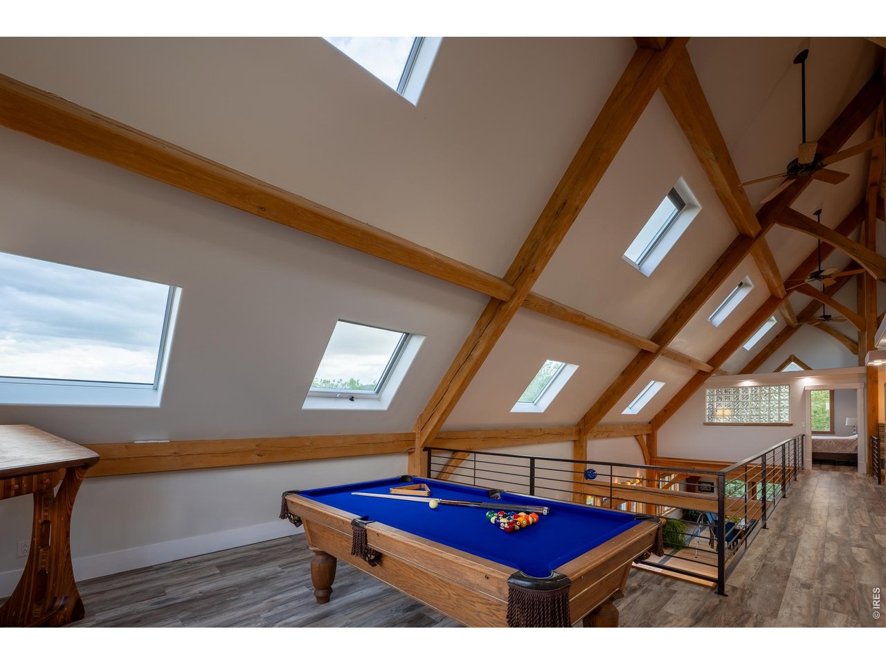 4099 Michaud Lane Fort Collins, CO 80521 - Photo 23 of 50 Looking across the upper level, you'll appreciate the thoughtful design, where expansive windows fill the home with natural light and showcase the exceptional wood craftsmanship that adds warmth and character throughout.