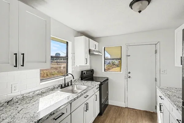 a spacious bathroom with a granite countertop sink and a mirror