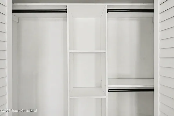 a view of walk in closet with empty racks