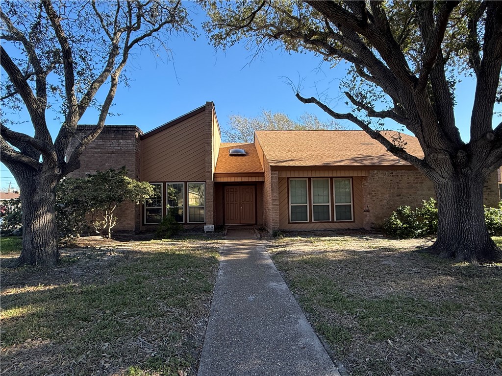 a front view of a house with a yard and trees