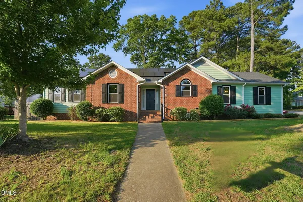 a front view of a house with yard and green space