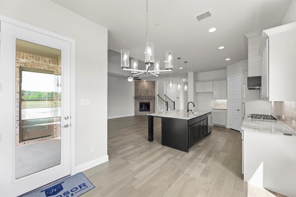 708 Splendor Drive McKinney, TX 75072 - Photo 14 of 29 a large white kitchen with a large counter top stainless steel appliances and cabinets
