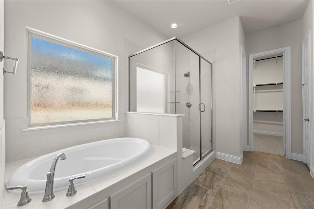 708 Splendor Drive McKinney, TX 75072 - Photo 16 of 29 a bathroom with a tub a sink and a large mirror