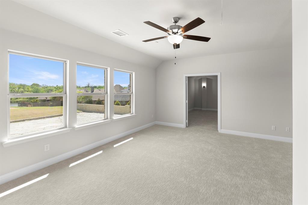 708 Splendor Drive McKinney, TX 75072 - Photo 20 of 29 an empty room with large windows and a ceiling fan