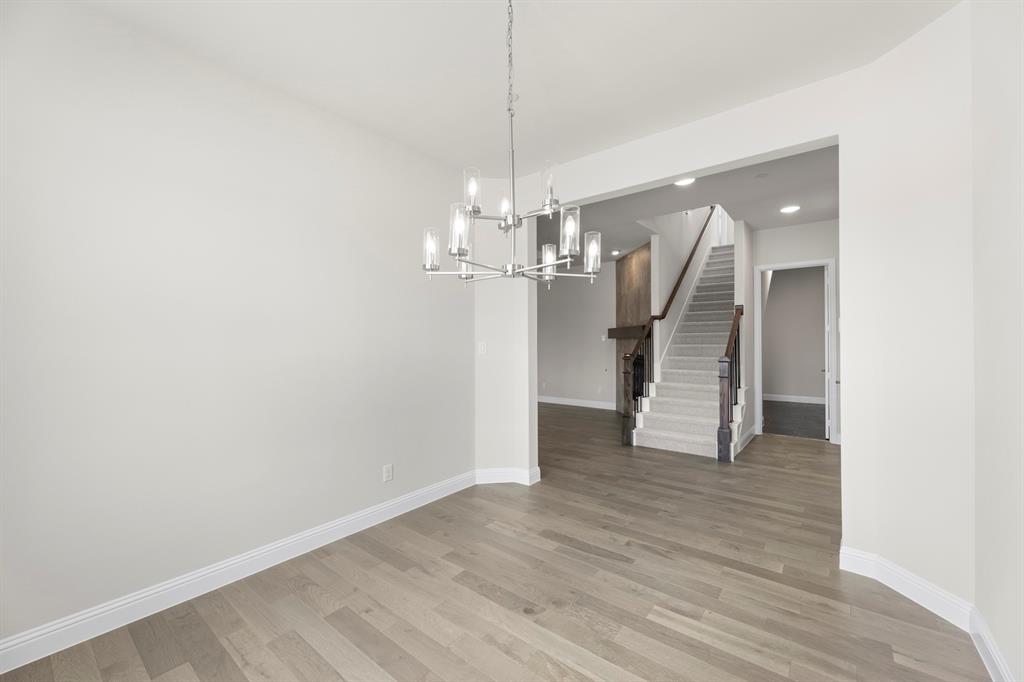 708 Splendor Drive McKinney, TX 75072 - Photo 6 of 29 a view of a hallway with wooden floor and chandelier