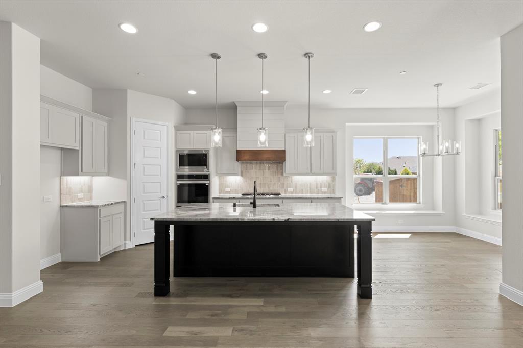 708 Splendor Drive McKinney, TX 75072 - Photo 10 of 29 a kitchen with kitchen island a sink stainless steel appliances and cabinets
