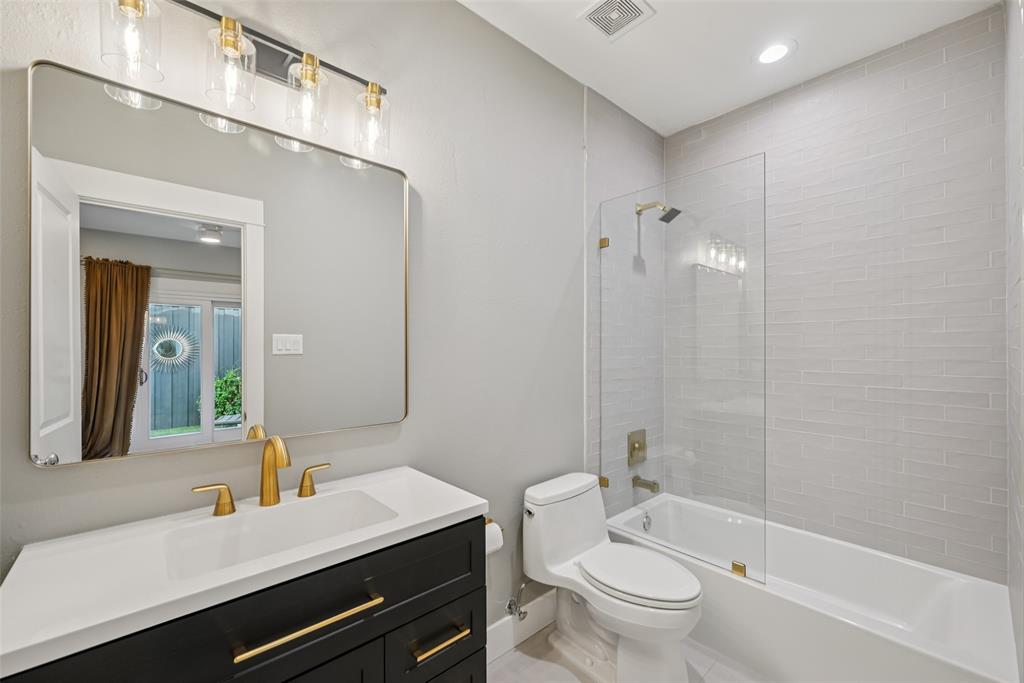 3926 Holland Avenue, Unit 102 Dallas, TX 75219 - Photo 10 of 40 a bathroom with a sink a toilet a mirror and shower