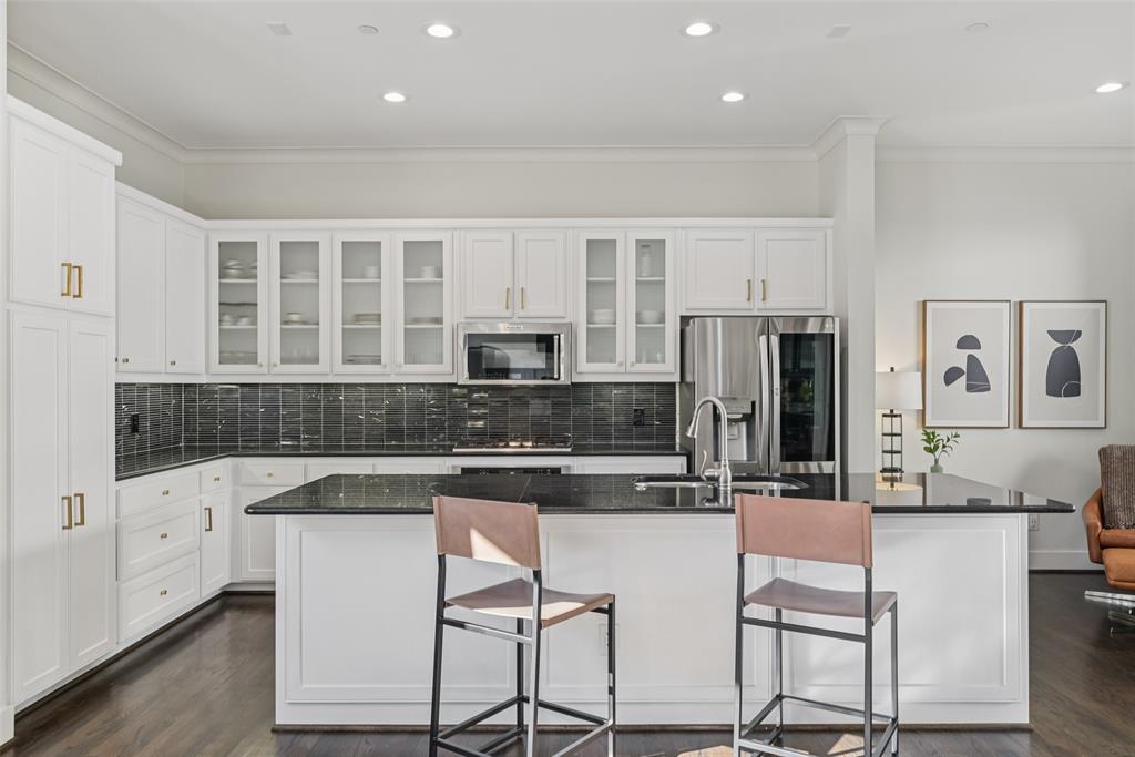3926 Holland Avenue, Unit 102 Dallas, TX 75219 - Photo 13 of 40 a kitchen with stainless steel appliances granite countertop a stove top oven a sink a refrigerator and white cabinets