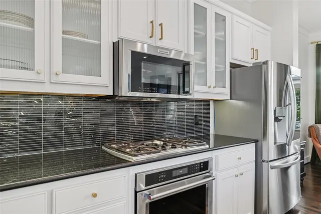 a open kitchen with granite countertop a sink and white cabinets