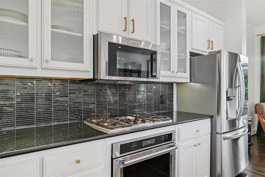 3926 Holland Avenue, Unit 102 Dallas, TX 75219 - Photo 19 of 40 a kitchen with granite countertop a stove and a refrigerator