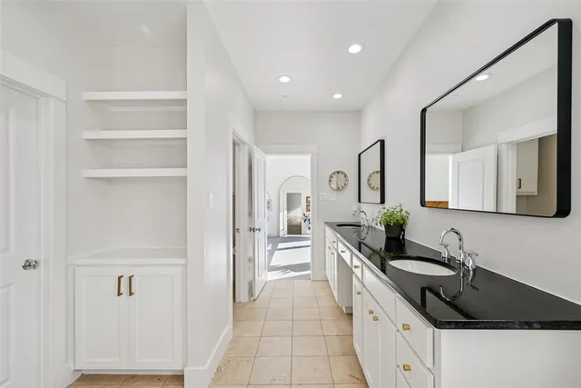 a spacious bathroom with a granite countertop sink and a mirror