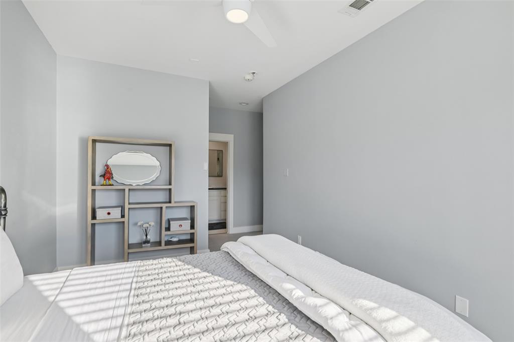 3926 Holland Avenue, Unit 102 Dallas, TX 75219 - Photo 31 of 40 a bedroom with a bed and a table in it