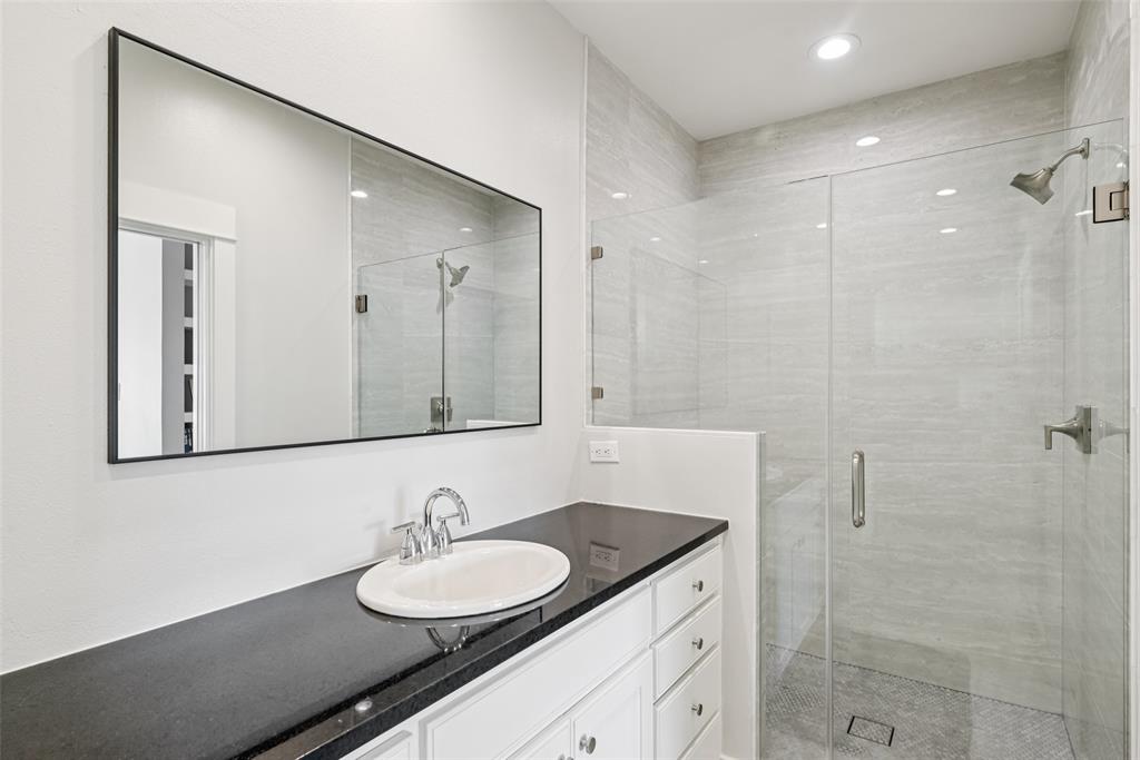 3926 Holland Avenue, Unit 102 Dallas, TX 75219 - Photo 33 of 40 a bathroom with a granite countertop sink and a mirror