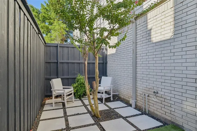 a view of backyard with a chair and potted plants