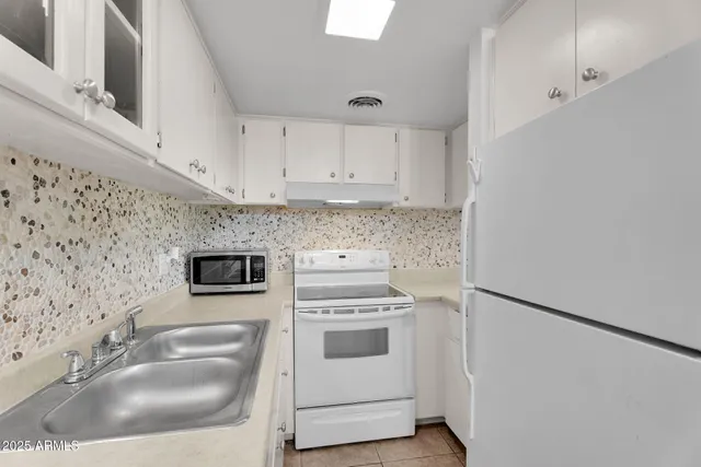 a kitchen with stainless steel appliances granite countertop a refrigerator and a stove
