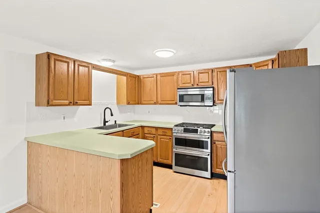 a kitchen with stainless steel appliances a stove sink and microwave