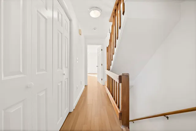 a view of a hallway with wooden floor and entryway