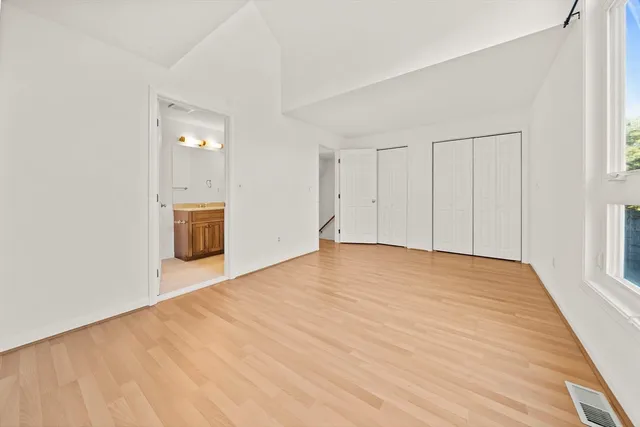 a view of empty room with wooden floor and cabinet