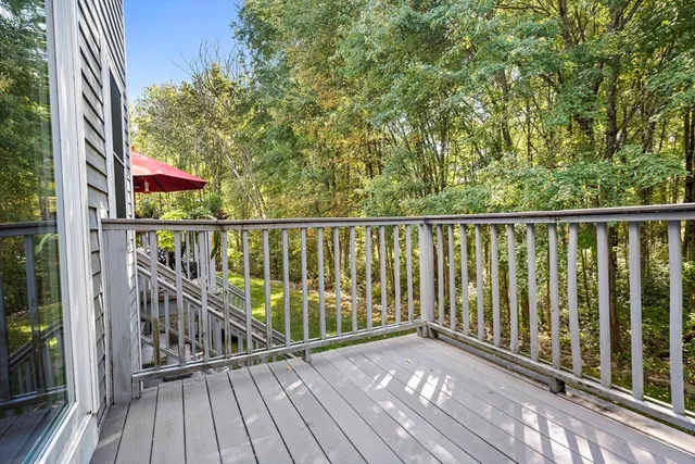 a view of balcony with wooden floor and fence and floor to ceiling window
