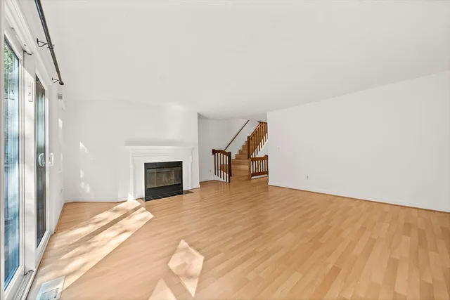 a view of a livingroom with wooden floor and a fireplace