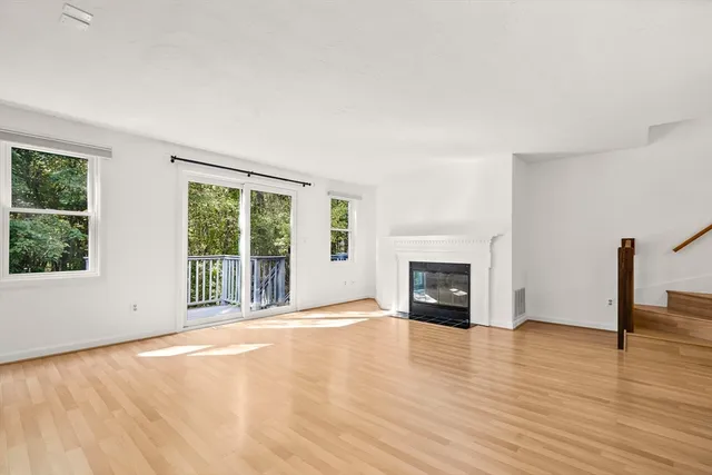 wooden floor fireplace and windows in an empty room