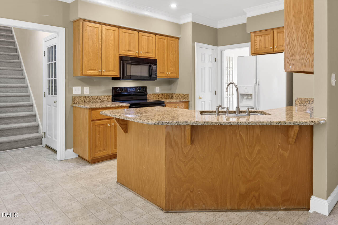 2209 Lodestar Drive Raleigh, NC 27615 - Photo 5 of 50 a kitchen with stainless steel appliances granite countertop a refrigerator a stove top oven a sink and dishwasher