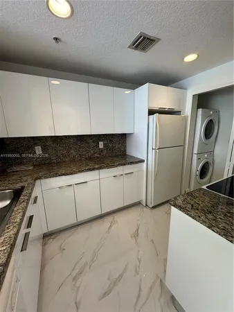a kitchen with refrigerator and cabinets