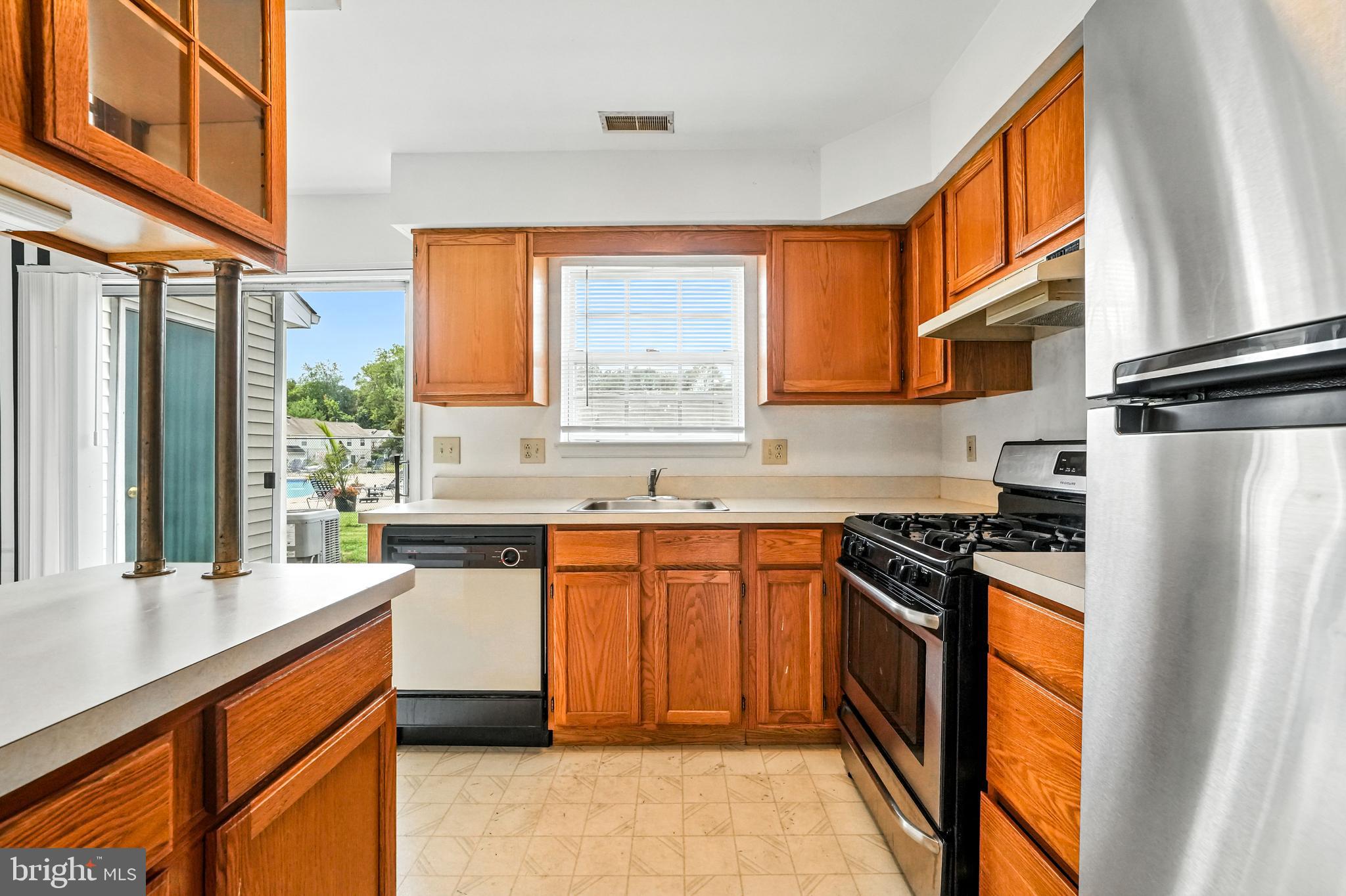 2002 Tall Pines Pine Hill, NJ 08021 - Photo 16 of 31 a kitchen with stainless steel appliances granite countertop a refrigerator a sink dishwasher a stove and white countertops with wooden floor