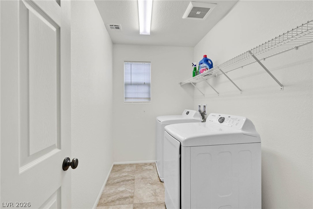 155 Fulgora Street Henderson, NV 89074 - Photo 18 of 30 Functional laundry space featuring modern appliances and practical storage solutions.