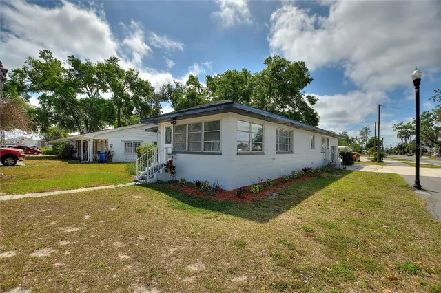 a view of a house with backyard and a tree